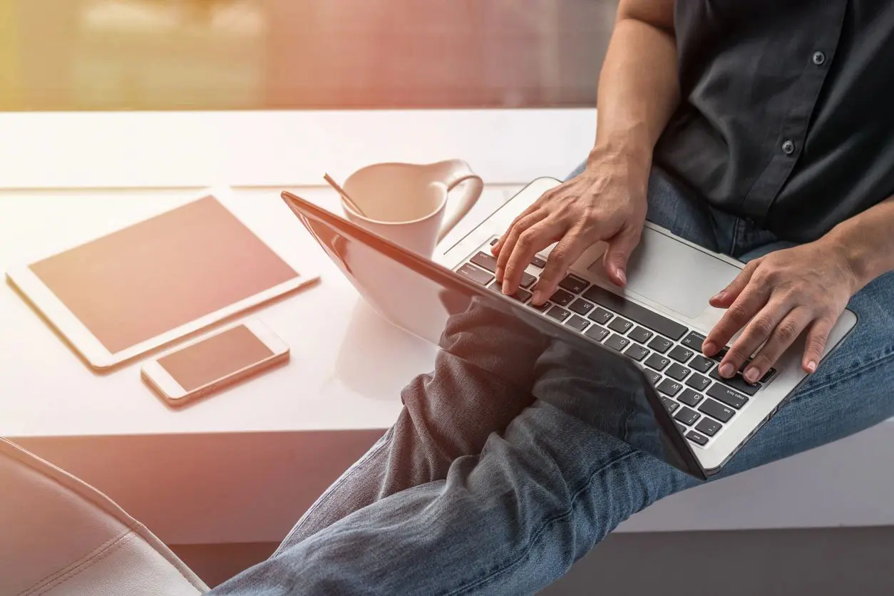 A person sitting at a table with a laptop.