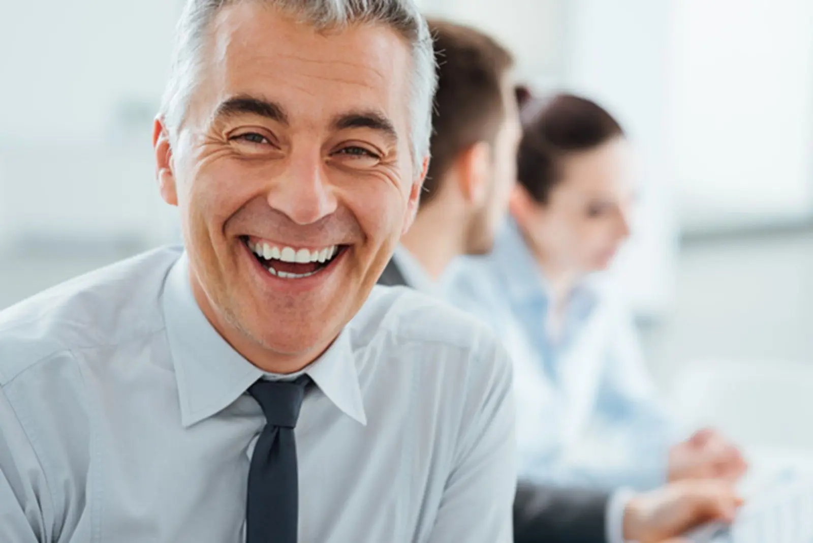 A man in a tie smiling for the camera.